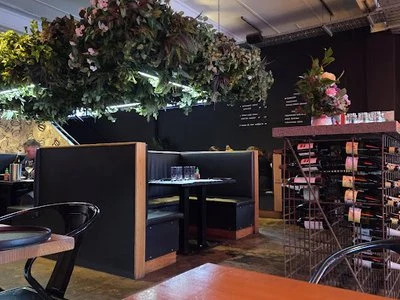 Booth seating beneath an abundant floral canopy inside Little Prince Eating House & Bar.