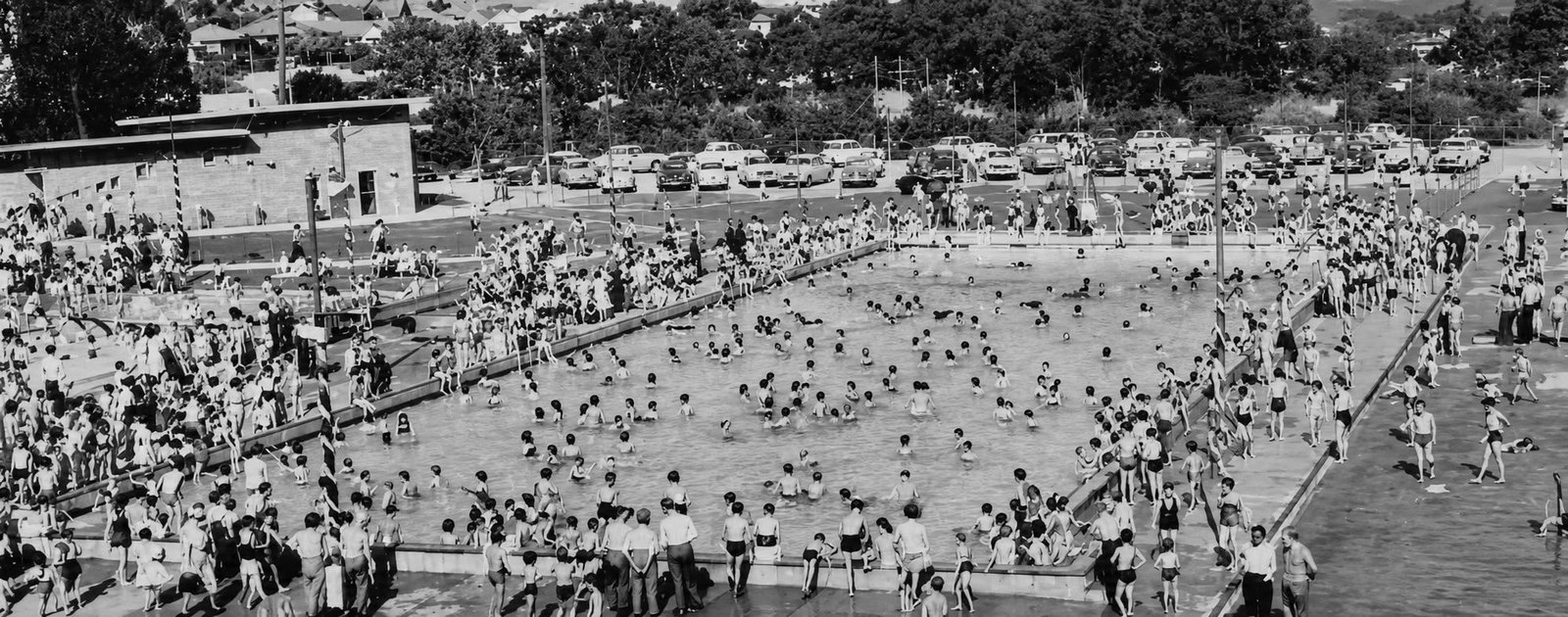 Panoramic historical view of swimmers and spectators at the Yallourn swimming pool.