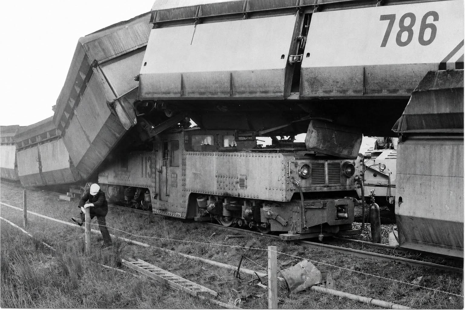 A derailed railway carriage resting across an electric locomotive at the Yallourn open cut.