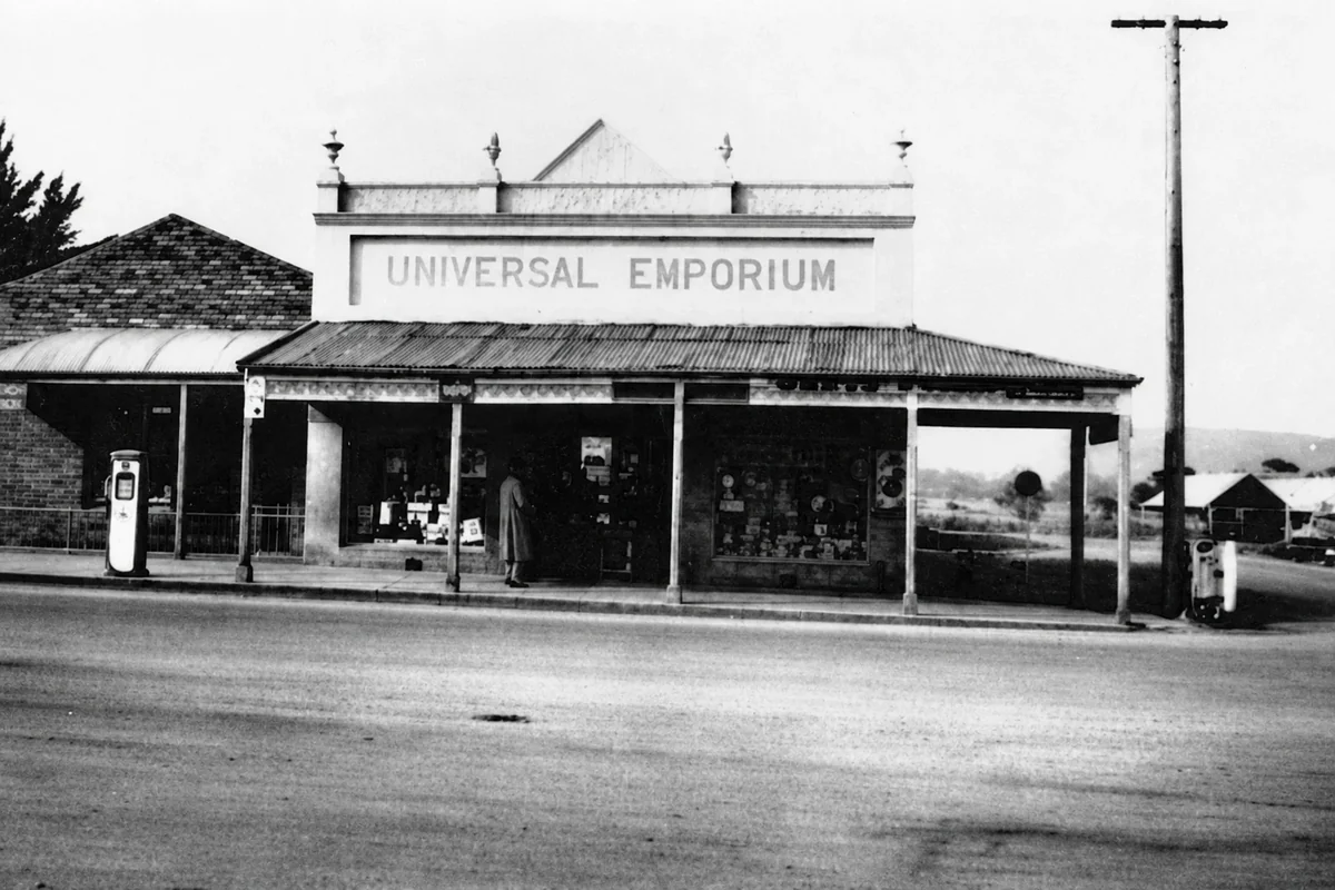 The Universal Emporium shopfront in Yinnar in June 1959, with display windows, verandah and fuel pumps.