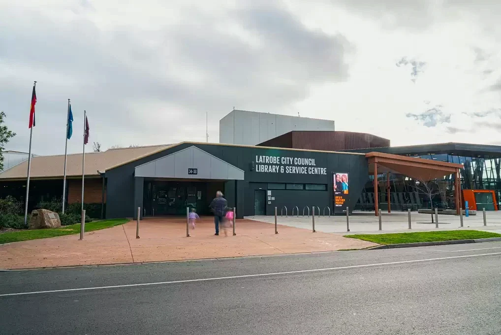 An adult and two children approach Traralgon Library and Service Centre from the street.