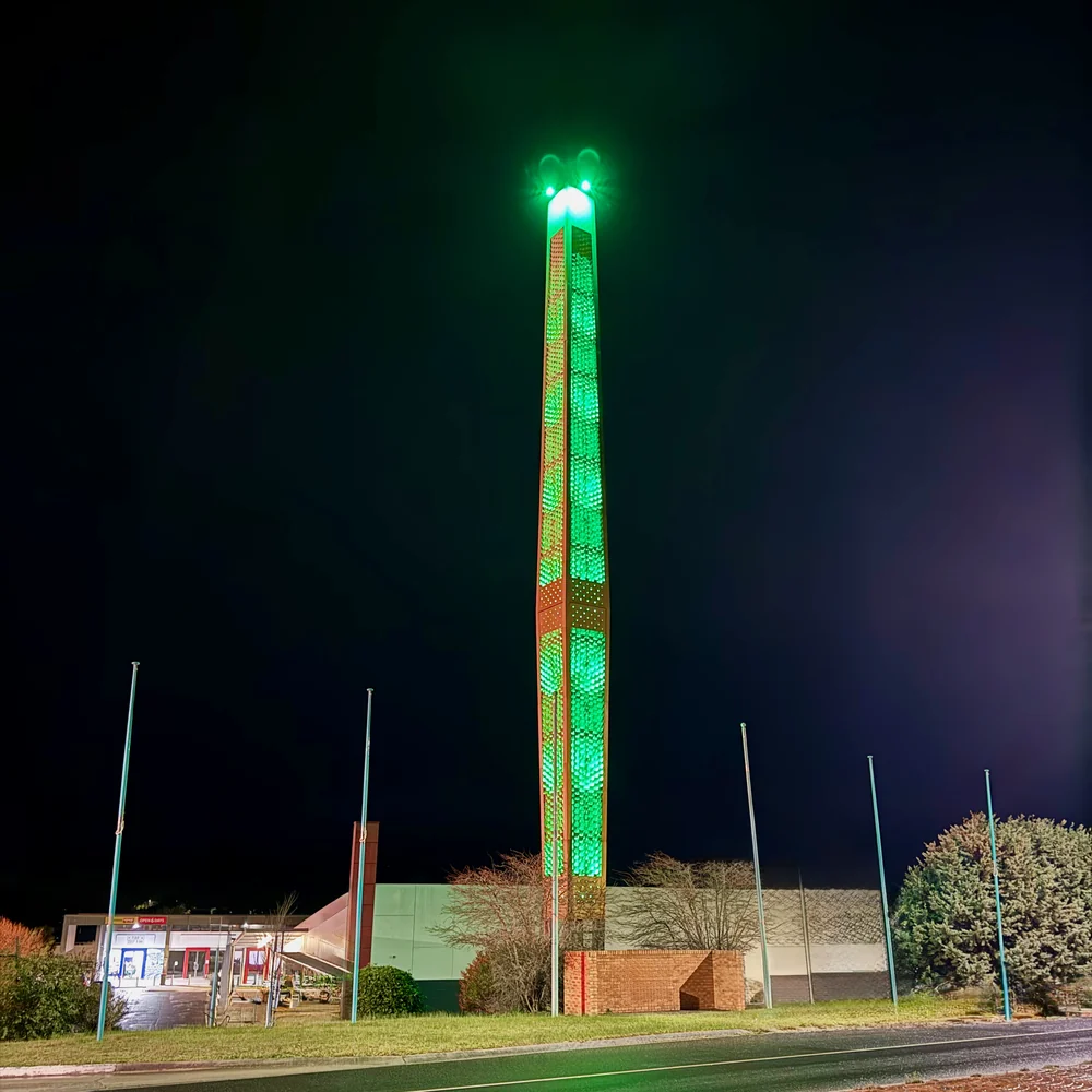 Churchill's tall town symbol illuminated green against the night sky above the town centre.